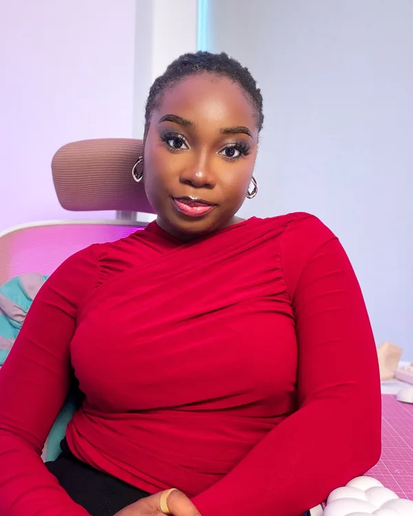 Omobolaji wearing wine red, seated in her workspace